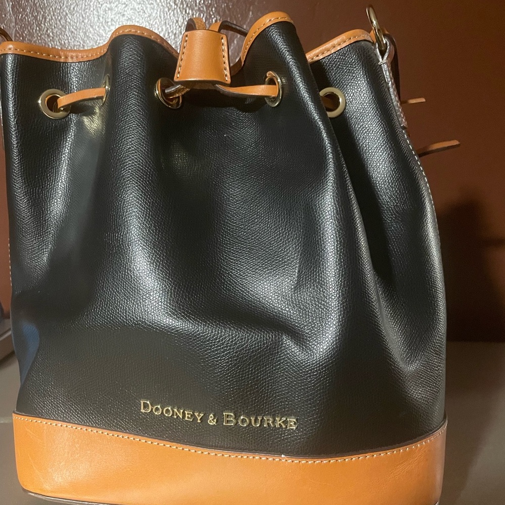 Dooney and Bourke, black and tan medium bucket bag with drawstring gently used